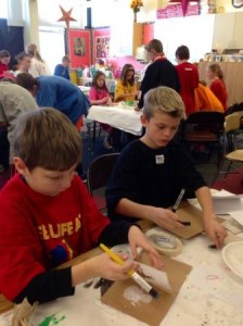 5th grade carefully working on their stenciled cards.
