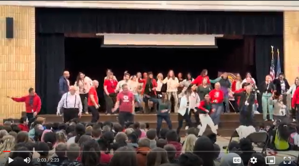 Image is clickable and takes user to a video of teachers dancing at a dance assembly
