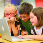 Children learning together around computer