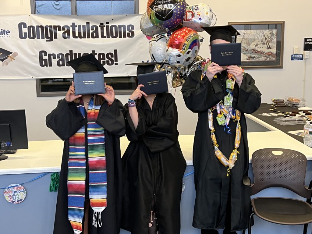 Graduating students with diplomas