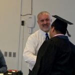 Principal presenting diploma to student